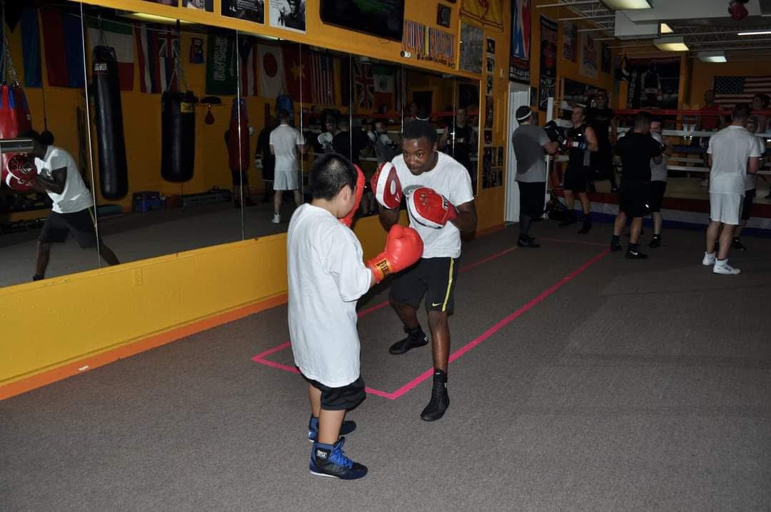 Roy Wayne demonstrating stance and distance with a youth boxer